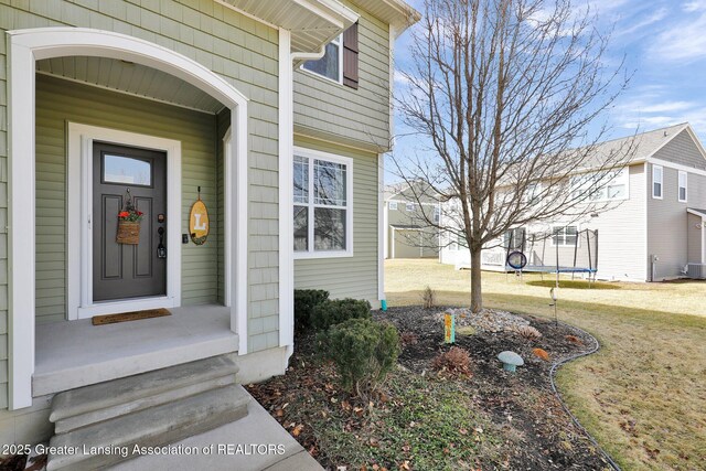 property entrance with a yard and central AC unit