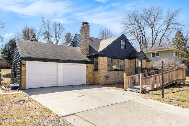 view of front of home featuring driveway, a shingled roof, a chimney, a garage, and brick siding