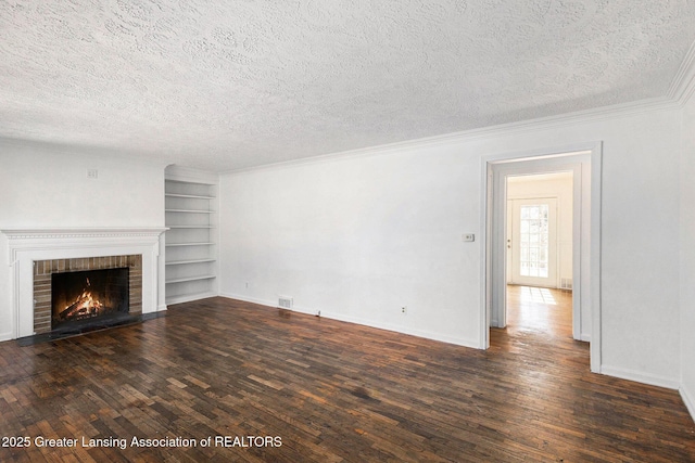 unfurnished living room featuring wood-type flooring, a textured ceiling, built in shelves, and a fireplace