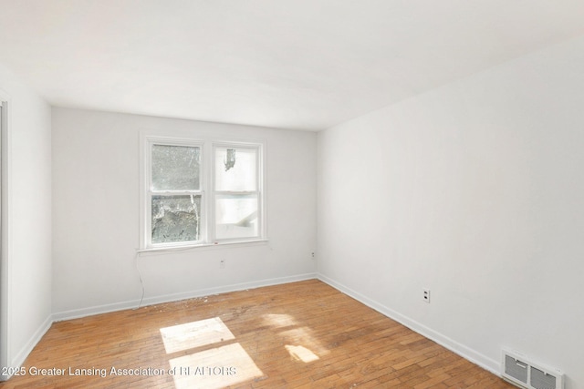 spare room featuring visible vents, baseboards, and light wood-style floors