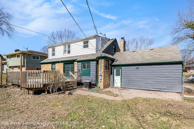 rear view of house with a wooden deck, a chimney, and central AC