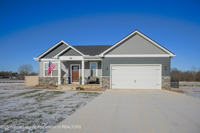 craftsman inspired home with a garage, stone siding, and driveway