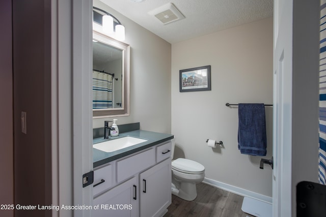 2860 Black Oak St, Webberville, MI 48892 - full bath featuring a textured ceiling, visible vents, wood finished floors, toilet, and vanity