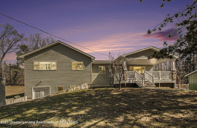 back of house at dusk with a yard and covered porch