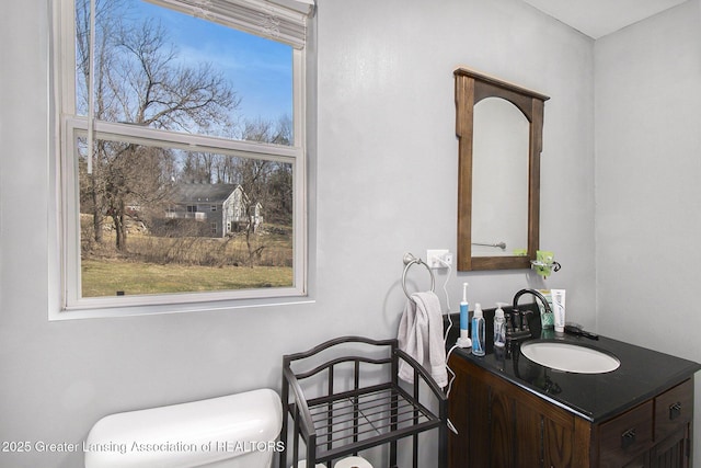 bathroom featuring a wealth of natural light, toilet, and vanity