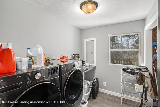 laundry area featuring washing machine and clothes dryer, baseboards, laundry area, wood finished floors, and a textured ceiling