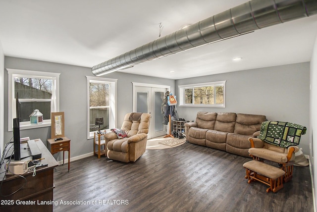 living area featuring baseboards and dark wood finished floors