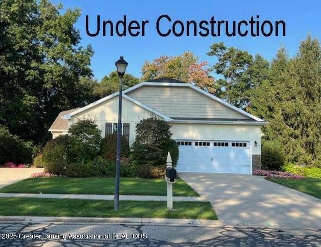 view of front of home with driveway, a front yard, and an attached garage