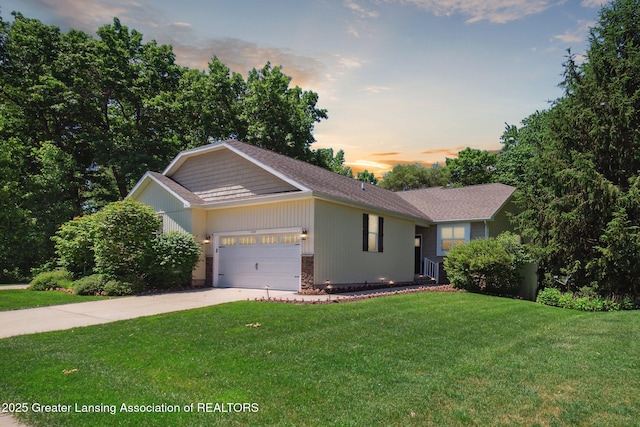 view of front facade featuring a lawn, concrete driveway, and a garage