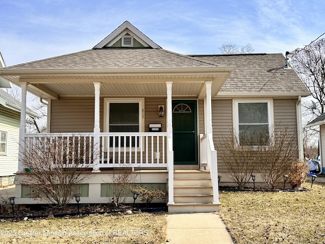 bungalow with covered porch and a shingled roof