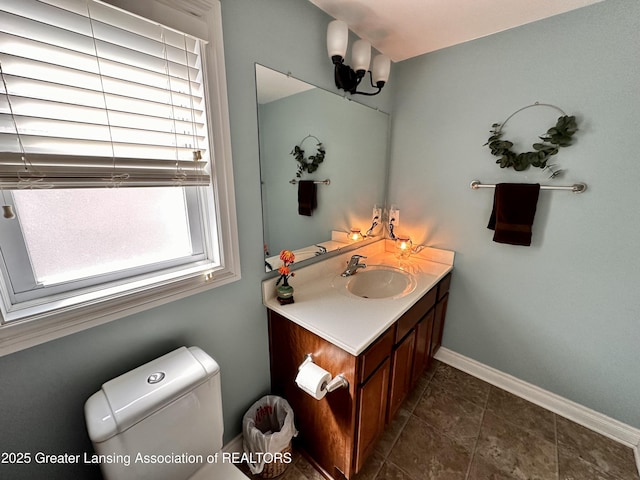 bathroom featuring baseboards, toilet, vanity, and tile patterned flooring