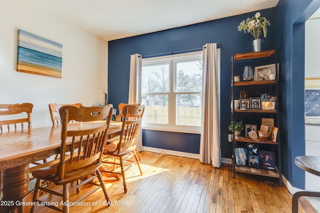 dining space featuring baseboards and wood-type flooring