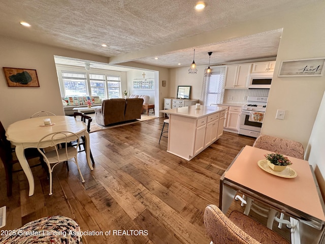 1793 N Shore Dr, Crystal, MI 48818 - kitchen featuring dark wood-type flooring, a textured ceiling, white cabinetry, and white appliances