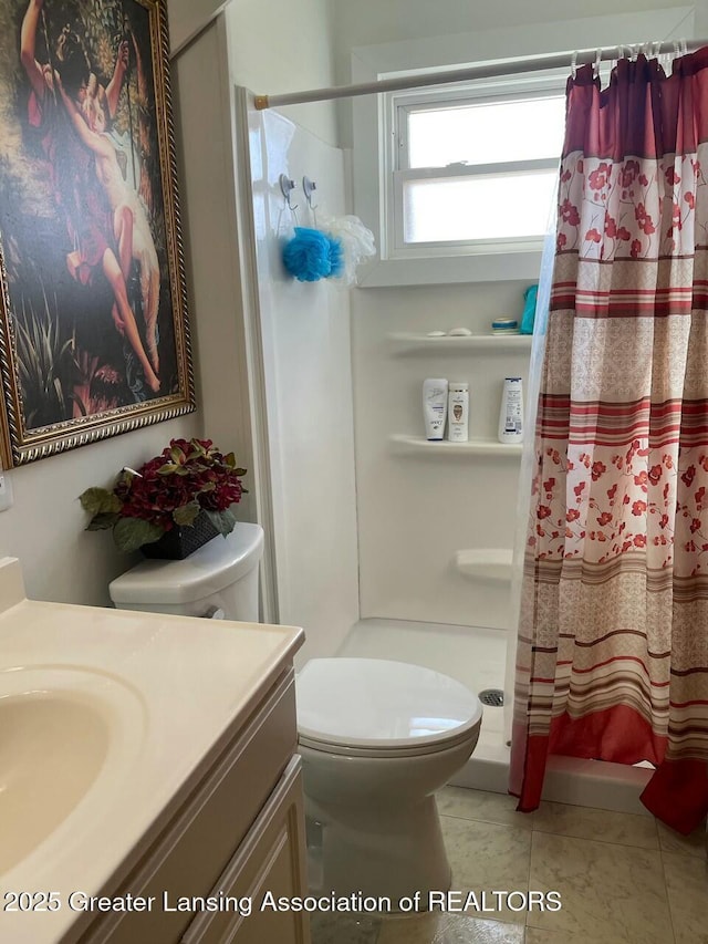 full bathroom featuring a stall shower, toilet, and vanity