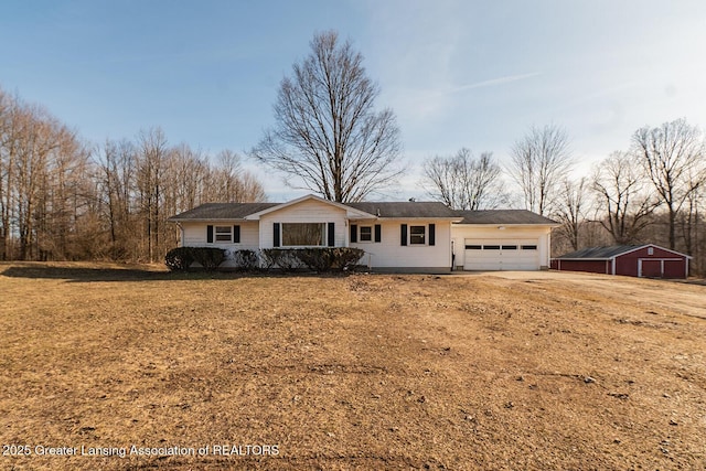 ranch-style house featuring an attached garage, driveway, and a front yard