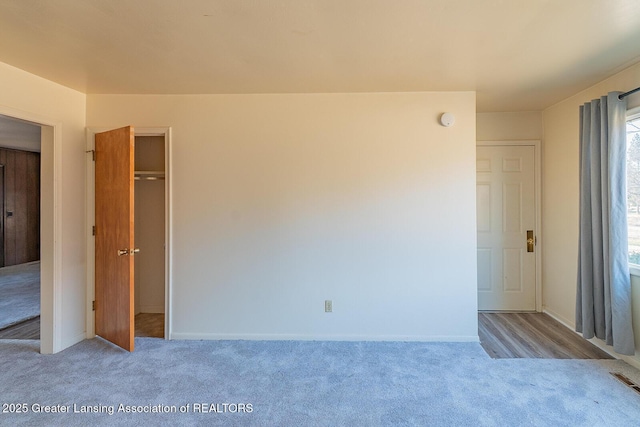 unfurnished bedroom featuring a closet, carpet flooring, visible vents, and baseboards