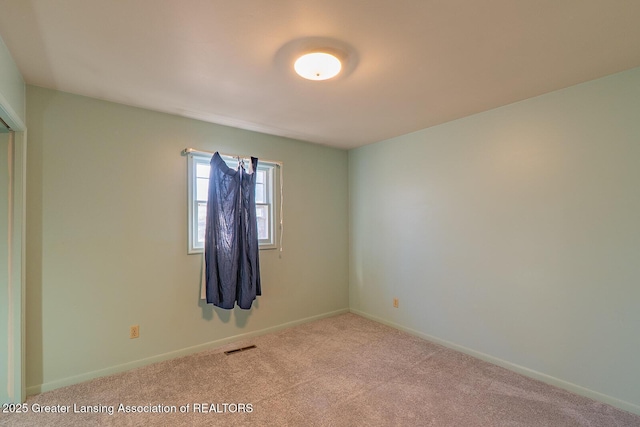 carpeted empty room with visible vents and baseboards