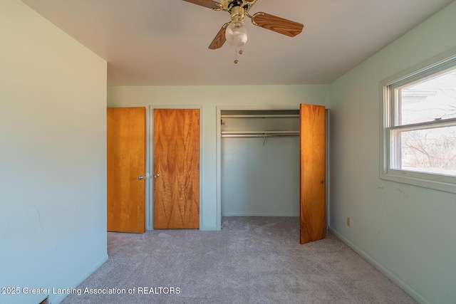 unfurnished bedroom featuring baseboards, carpet floors, and multiple closets