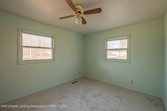 carpeted empty room featuring plenty of natural light, baseboards, and ceiling fan