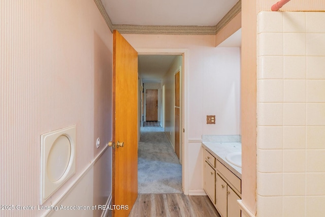 bathroom featuring wood finished floors, vanity, and crown molding