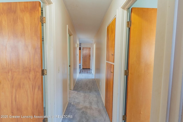 hallway with carpet flooring and baseboards