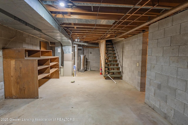 unfinished below grade area with stairs, heating unit, and water heater