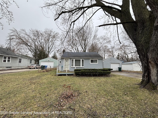 bungalow featuring an outdoor structure, driveway, a garage, and a front yard