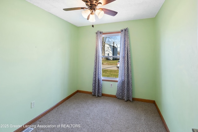 carpeted spare room featuring a ceiling fan, baseboards, and a textured ceiling