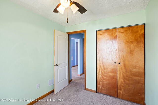 unfurnished bedroom with baseboards, carpet flooring, a textured ceiling, and visible vents