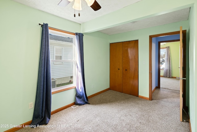 unfurnished bedroom with baseboards, a textured ceiling, a closet, and carpet
