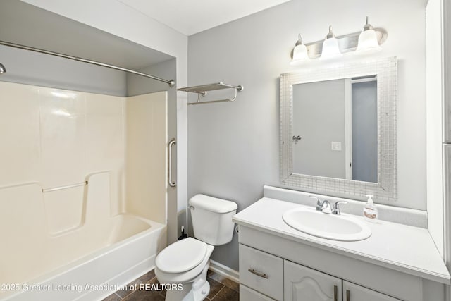 bathroom featuring baseboards, toilet, vanity, and shower / bathtub combination