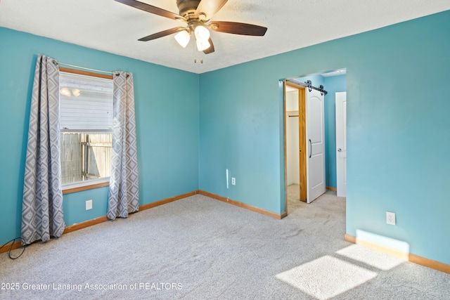 carpeted spare room with baseboards and ceiling fan