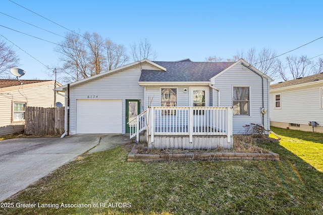 view of front of property featuring concrete driveway, fence, an attached garage, a front lawn, and a shingled roof