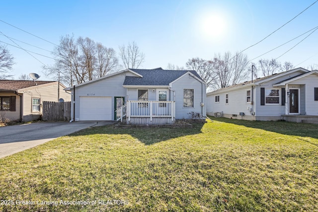 view of front of property with roof with shingles, fence, an attached garage, driveway, and a front yard