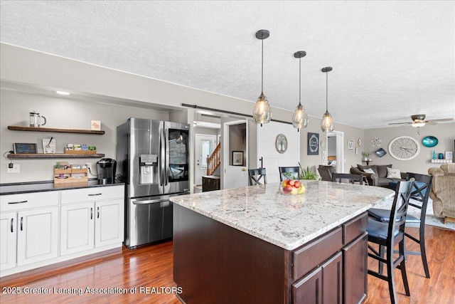 13305 Nelson, Bath, MI 48808 - kitchen with a kitchen island, dark wood-style flooring, ceiling fan, and stainless steel fridge