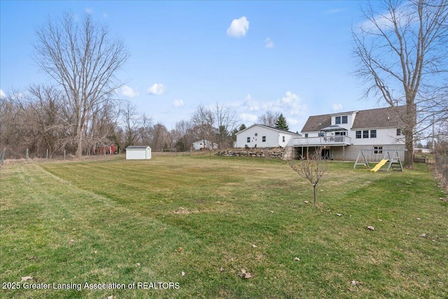 13305 Nelson, Bath, MI 48808 - view of yard featuring a wooden deck, a storage unit, a playground, and an outdoor structure