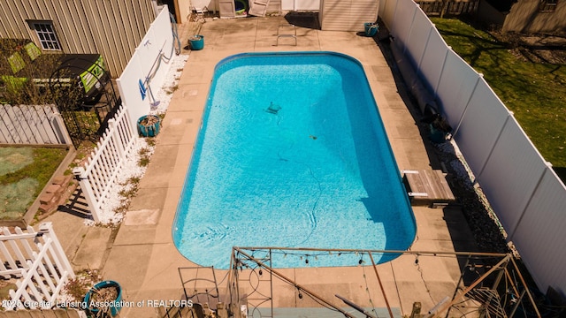 view of swimming pool with a fenced in pool, a patio area, a fenced backyard, and a diving board