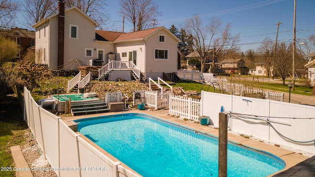 view of pool featuring a fenced backyard, a fenced in pool, a deck, and stairs