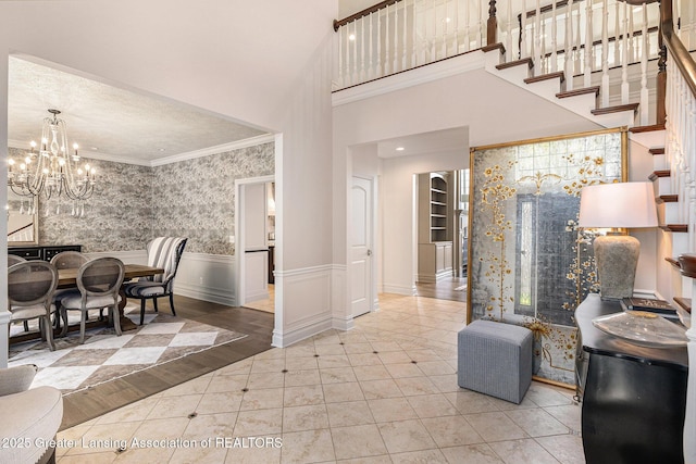 13600 Forest Hill Rd, Grand Ledge, MI 48837 - dining space featuring a chandelier, tile patterned flooring, ornamental molding, a wainscoted wall, and a high ceiling