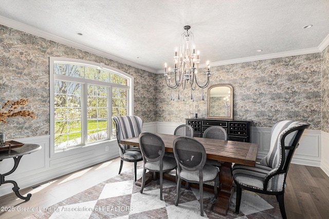 13600 Forest Hill Rd, Grand Ledge, MI 48837 - dining area featuring healthy amount of natural light, wood finished floors, a chandelier, wallpapered walls, and ornamental molding