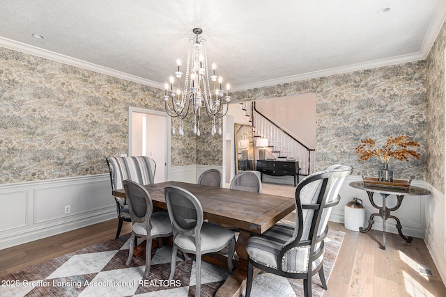 13600 Forest Hill Rd, Grand Ledge, MI 48837 - dining area featuring wallpapered walls, stairway, a chandelier, wood-type flooring, and a wainscoted wall