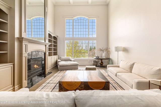 13600 Forest Hill Rd, Grand Ledge, MI 48837 - living area with healthy amount of natural light, wood finished floors, a premium fireplace, a towering ceiling, and built in shelves