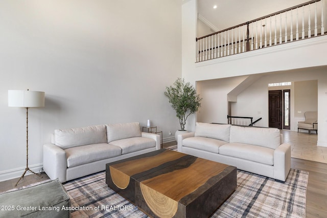 13600 Forest Hill Rd, Grand Ledge, MI 48837 - living room featuring a towering ceiling, baseboards, and wood finished floors