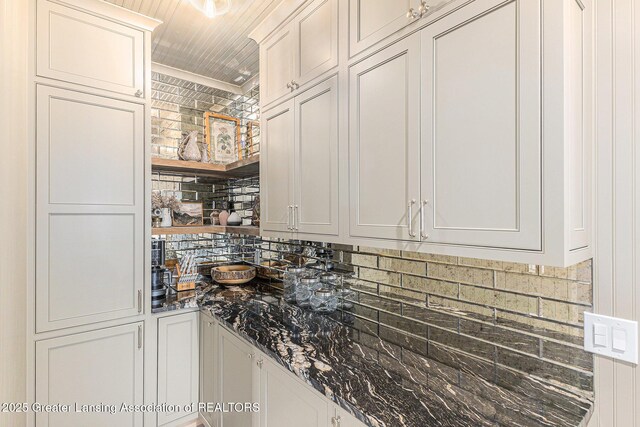 13600 Forest Hill Rd, Grand Ledge, MI 48837 - kitchen featuring backsplash, dark stone countertops, and white cabinetry