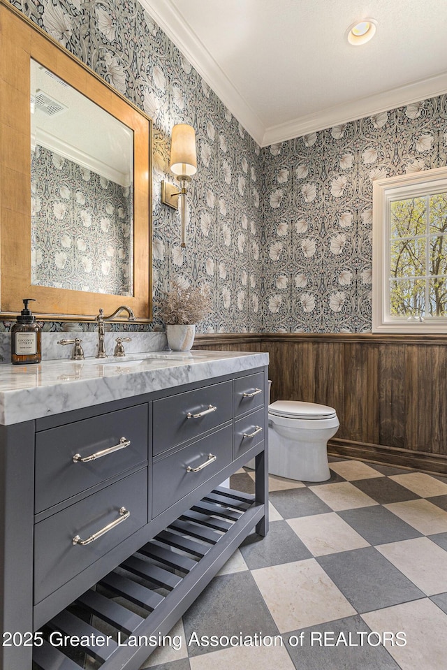 13600 Forest Hill Rd, Grand Ledge, MI 48837 - bathroom with ornamental molding, wainscoting, vanity, tile patterned floors, and toilet