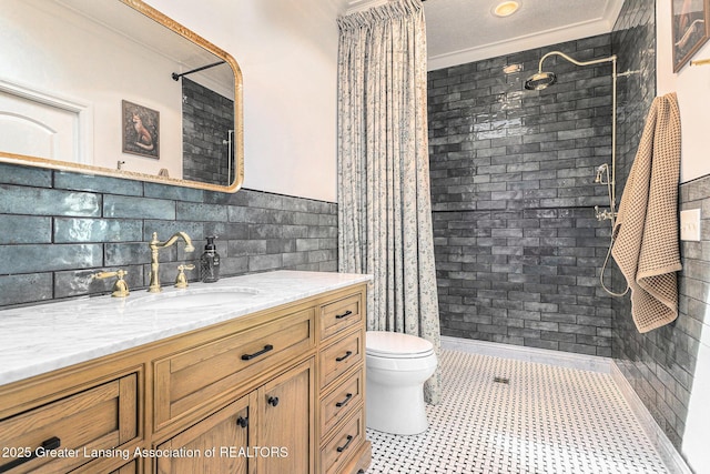 13600 Forest Hill Rd, Grand Ledge, MI 48837 - bathroom featuring crown molding, vanity, toilet, tiled shower, and tile walls