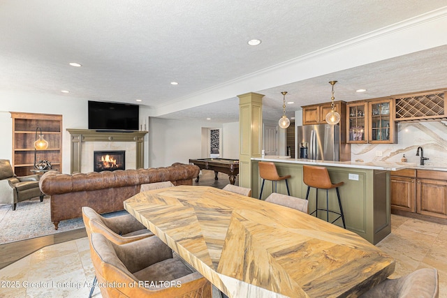 13600 Forest Hill Rd, Grand Ledge, MI 48837 - dining room featuring bar with sink, a textured ceiling, recessed lighting, a fireplace, and ornamental molding