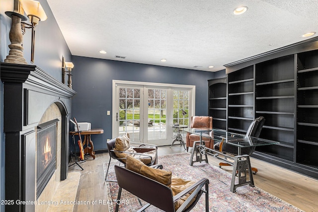 13600 Forest Hill Rd, Grand Ledge, MI 48837 - living area featuring a textured ceiling, hardwood / wood-style flooring, a fireplace with flush hearth, recessed lighting, and baseboards