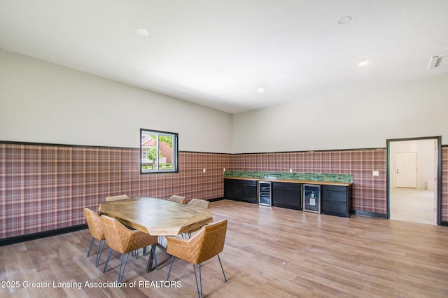 13600 Forest Hill Rd, Grand Ledge, MI 48837 - dining room with beverage cooler, wainscoting, light wood-style flooring, and tile walls