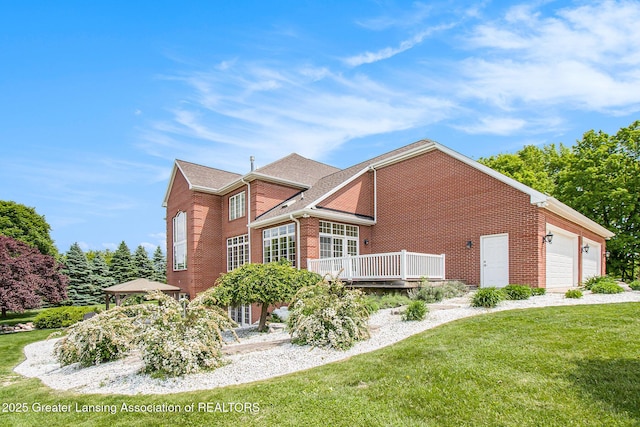 13600 Forest Hill Rd, Grand Ledge, MI 48837 - view of property exterior featuring brick siding, a garage, a yard, and a wooden deck